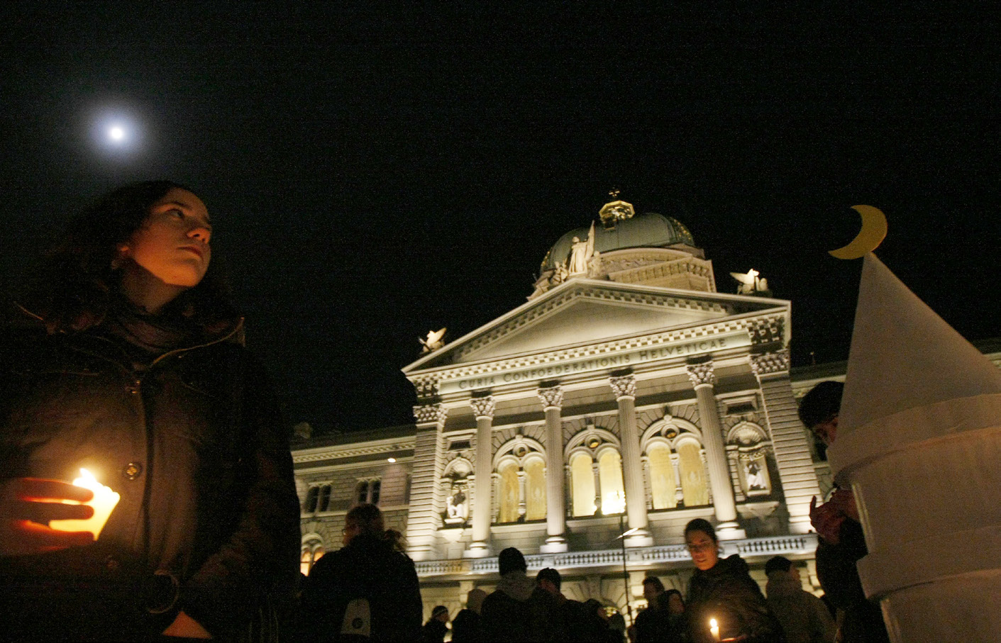 Protesters light candles after Switzerland bans the construction of minarets