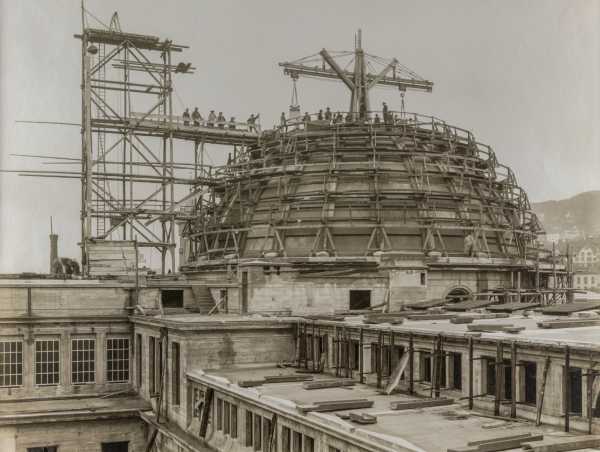 ca. 1918: Die ETH baut eine Kuppel auf ihr Hauptgbäude. Arbeiter posieren neben dem Drehkran.