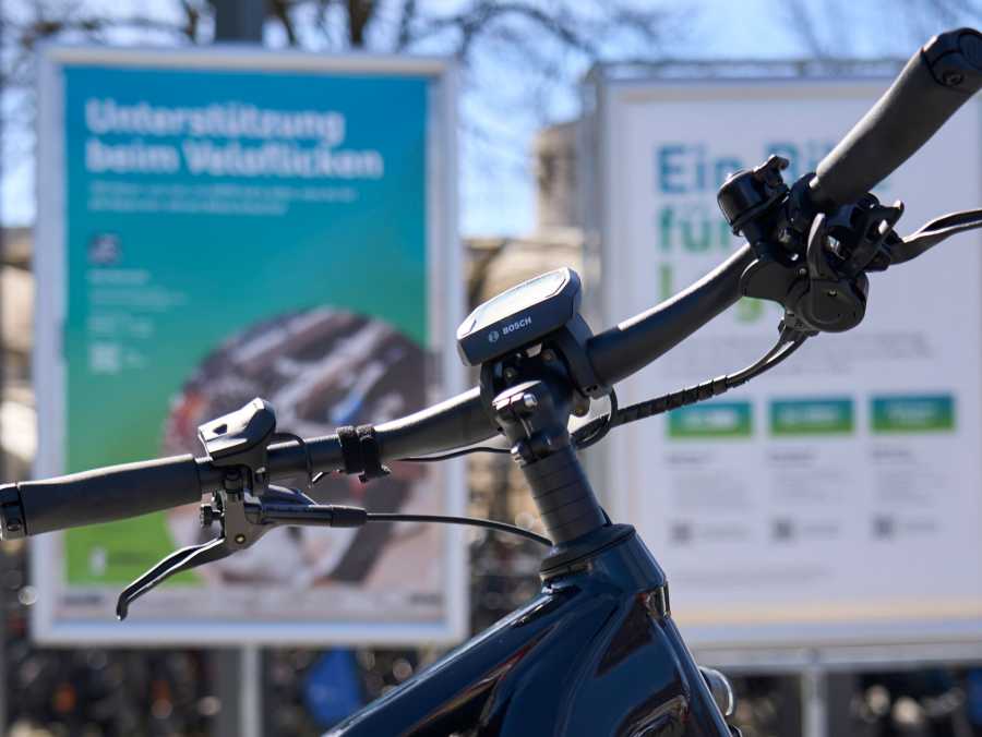 Vergrösserte Ansicht: Veloansicht im Vordergrung mit Plakaten zum Showcase Bikesharing im Hindergrund