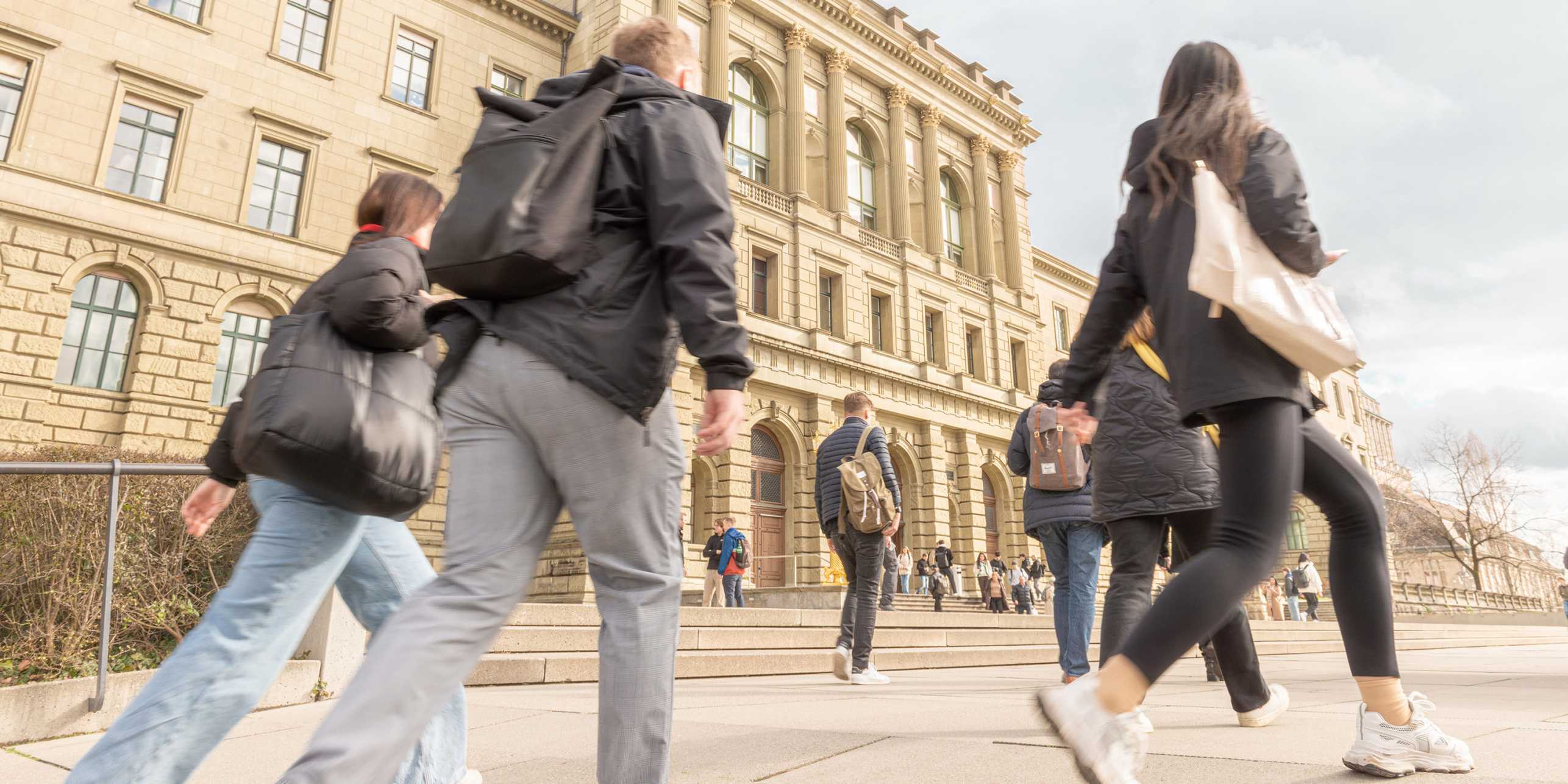 Mehrere Studierende laufen am ETH Hauptgebäude vorbei. Link zum Intern Aktuell Artikel.