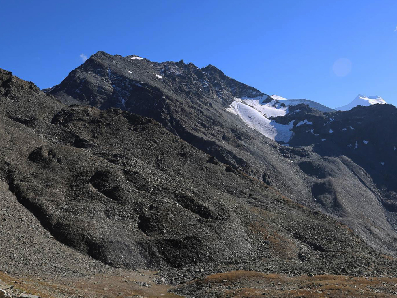 Vergrösserte Ansicht: Der Blockgletscher (linke Bildhälfte) am Fusse des Furggwanghorns (3161 m, nicht im Bild) im Wallis verändert seine Oberfläche rasant und kriecht immer rascher talwärts.