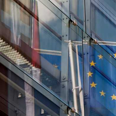 Schweizer und europäische Flagge spiegelt sich in Bürogebäude