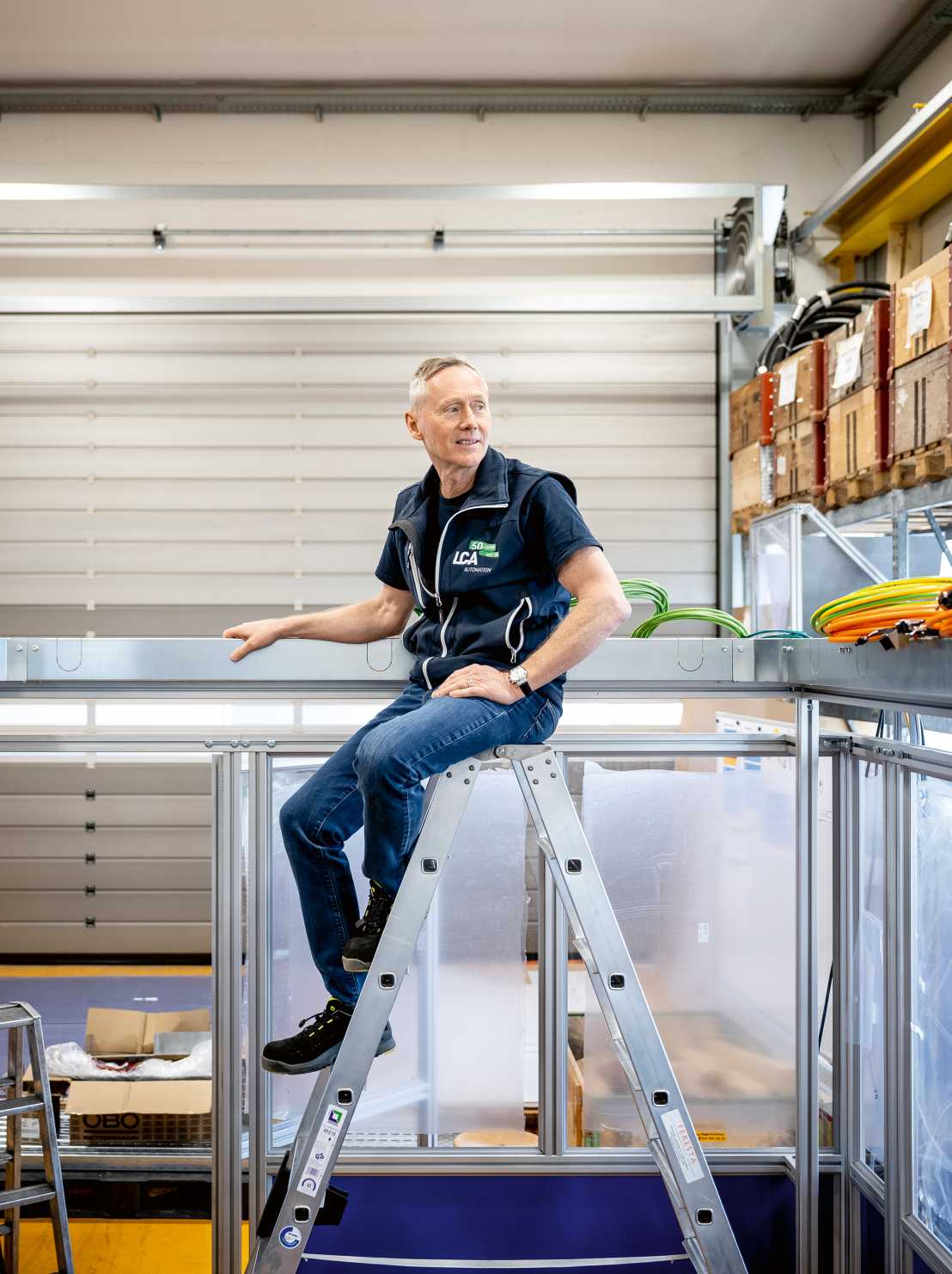 Christoph Rennhard sitzt oben auf einer Leiter