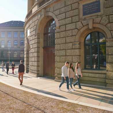Studierende laufen über dem Campus beim Hauptgebäude