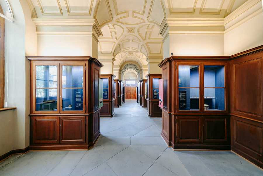 Vergrösserte Ansicht: Foyer der Sternwarte, Gang mit Vitrinen auf jeder Seite.