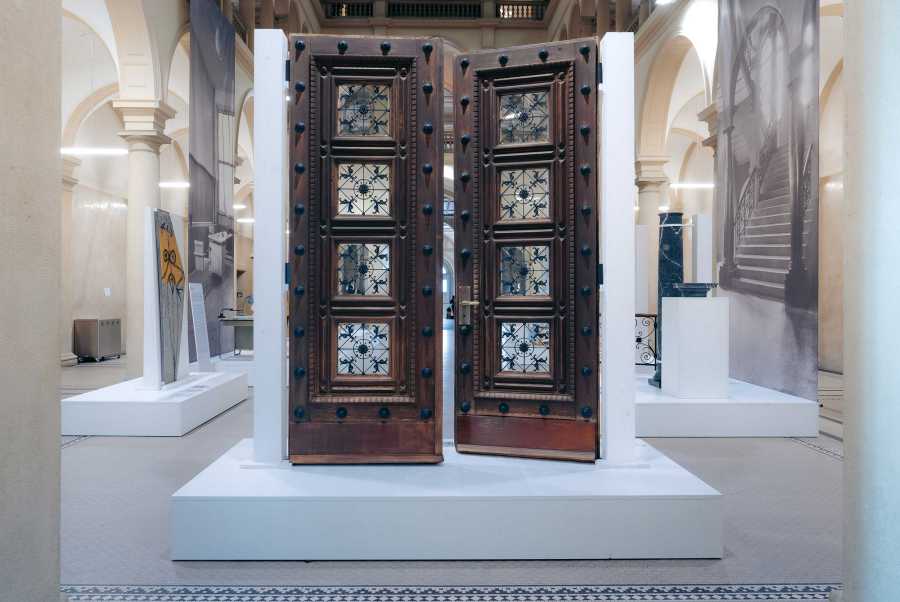 Vergrösserte Ansicht: Zweiflüglige Holztür in der Eingangshalle des ETH Gebäudes im Zentrum auf einem weissen Sockel ausgestellt.