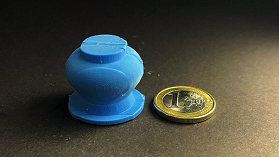 Der Saugnapf liegt neben einer 1 Euro Münze, der Saugnapf hat ungefähr denselben Durchmesser wie die Münze.