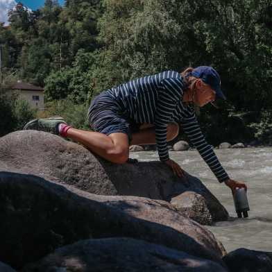 Frau nimmt Wasserproben aus dem Fluss