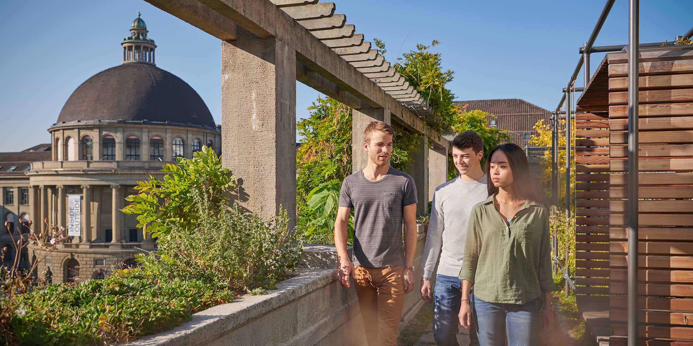 Studierende auf der ETH Terasse mit der Kuppel des Hauptgebäudes