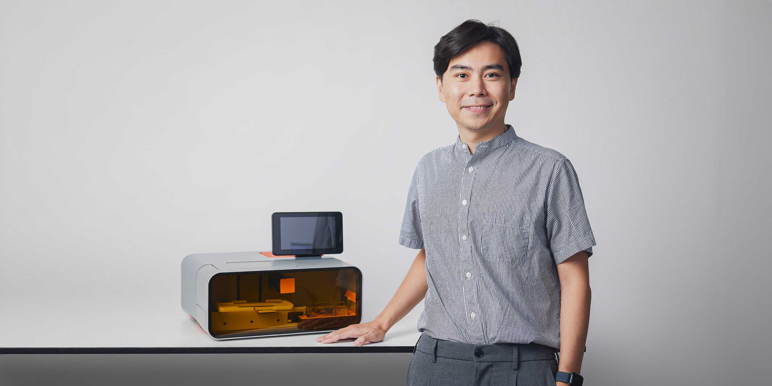 Hao Liu steht vor seinem entwickelten 3D Drucker 