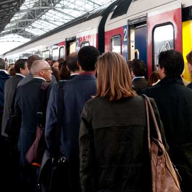 Viele Menschen an einem Bahnhof und sie steigen in einen Zug ein respektive aus