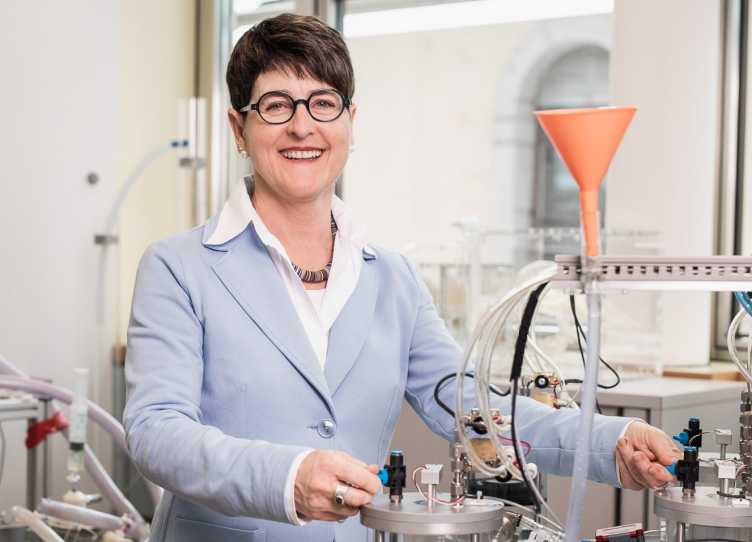 Vergrösserte Ansicht: Marianne Schmid Daners steht im Labor an einem Gerät