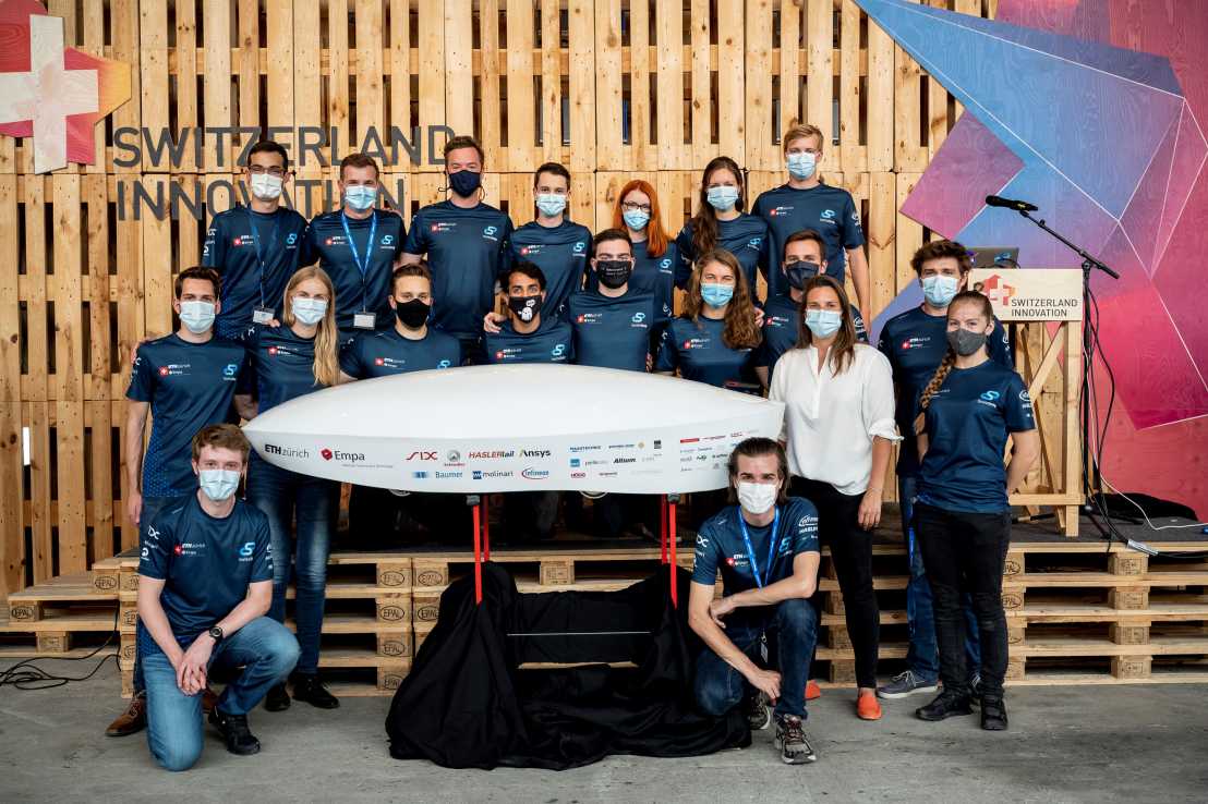 Teamfoto mit Hyperloop-Kapsel in der Mitte