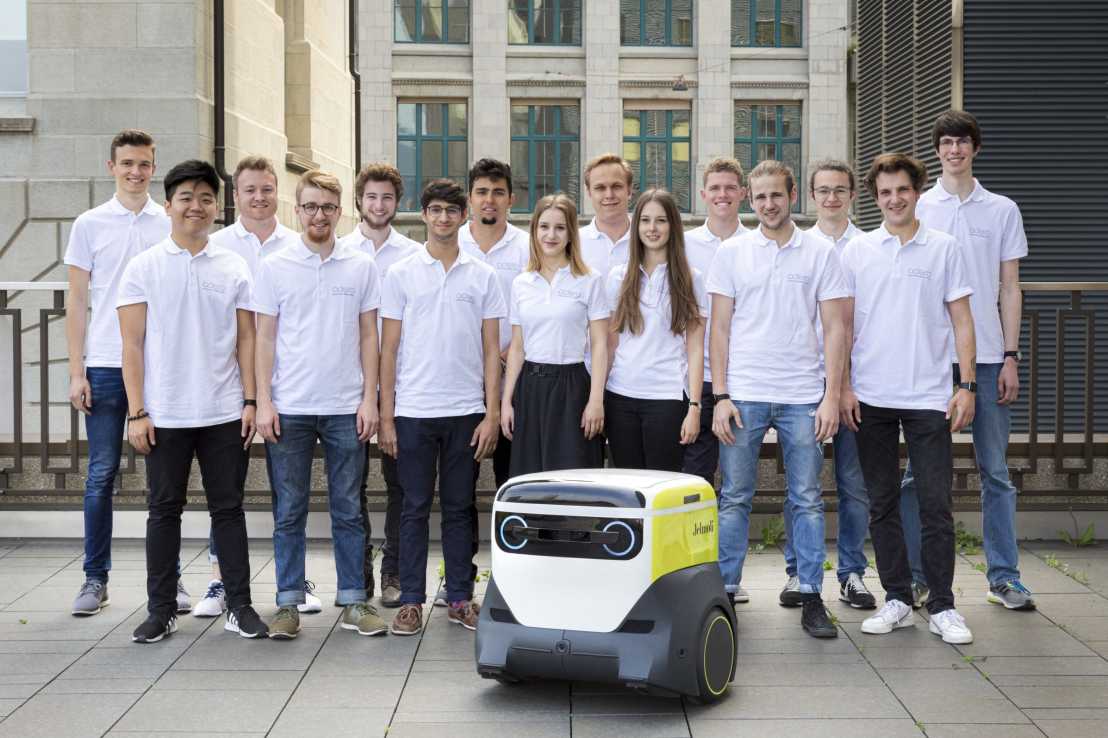 Teamfoto mit Adero-Roboter in der Mitte