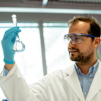 Maximilian Moser im Labor mit einer Flasche in der Hand