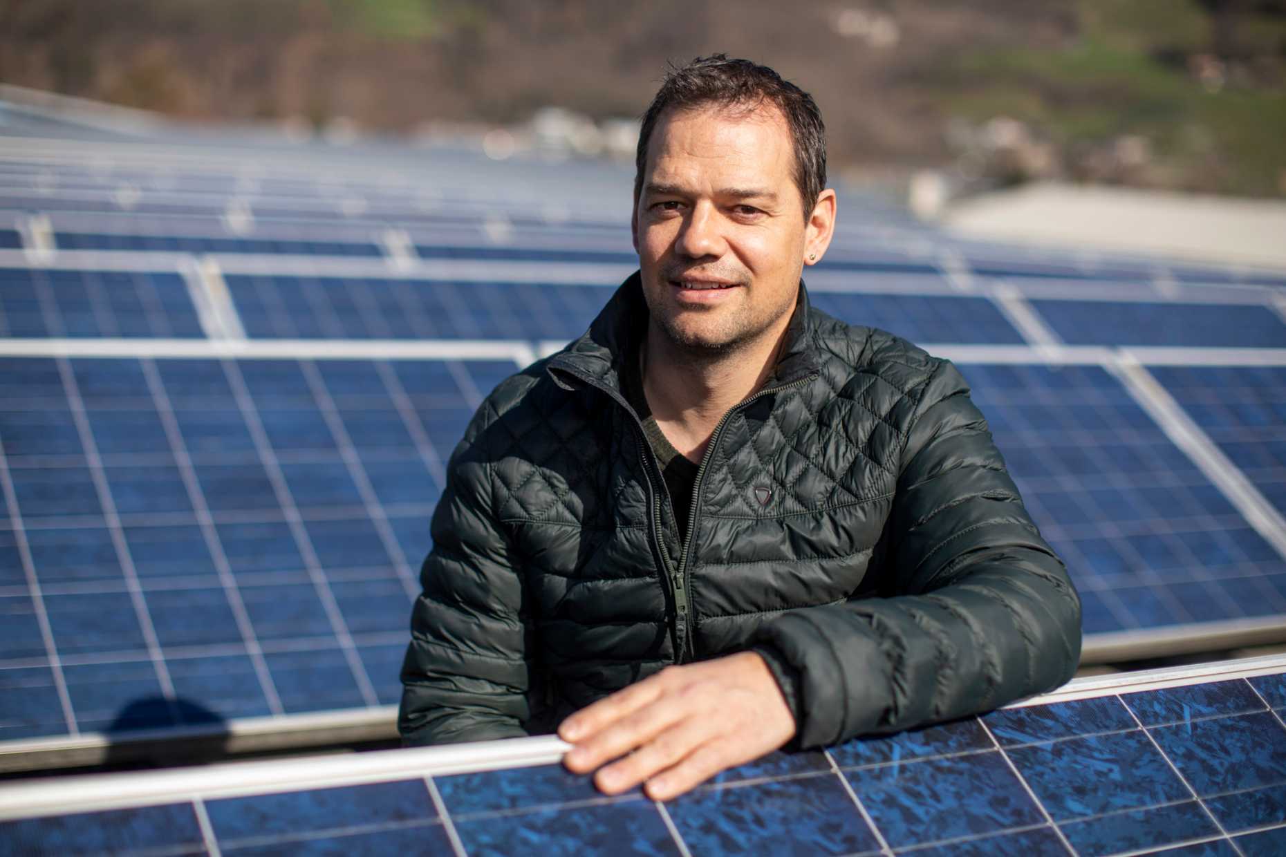 Christian Dürr on a roof with solar panels