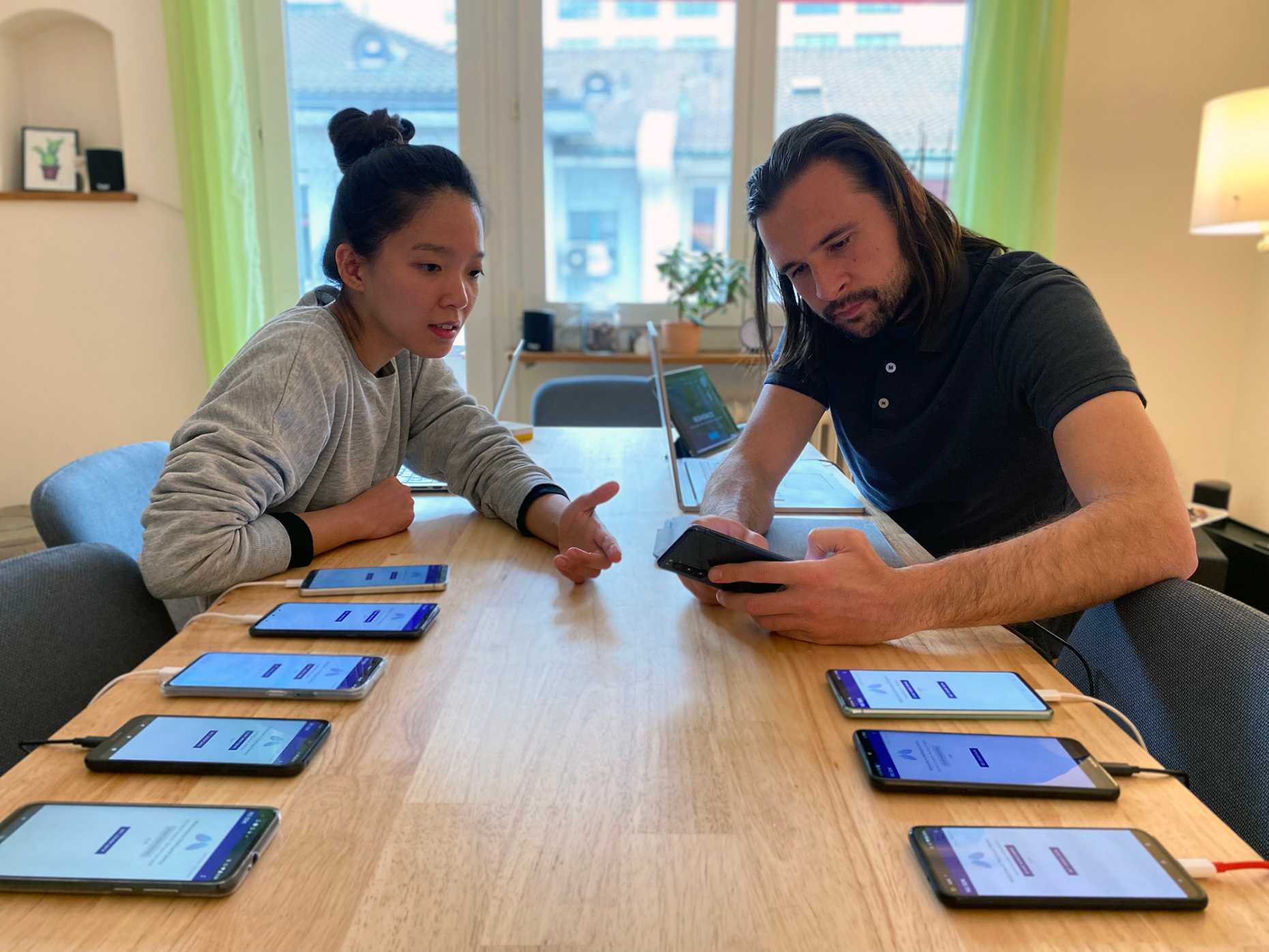 two people testing the app on several smartphones