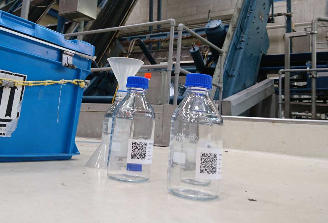 three bottles with sammple water from sewage plant and a device to test the water