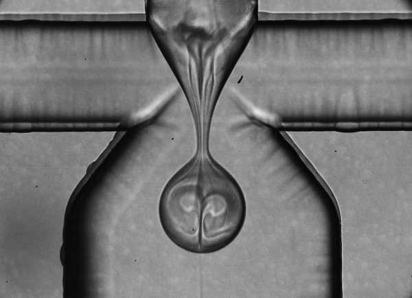 At the second branching, a drop surrounded by a particle-containing phase detaches into the continous phase.