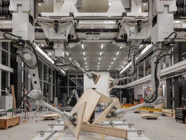 Roboterarme halten Holzplatten in einer Fertigungshalle