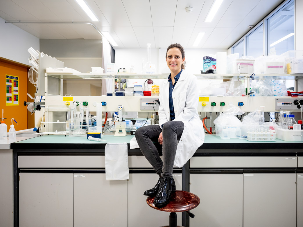 Nicole Stoffel sitting on a laboratory desk