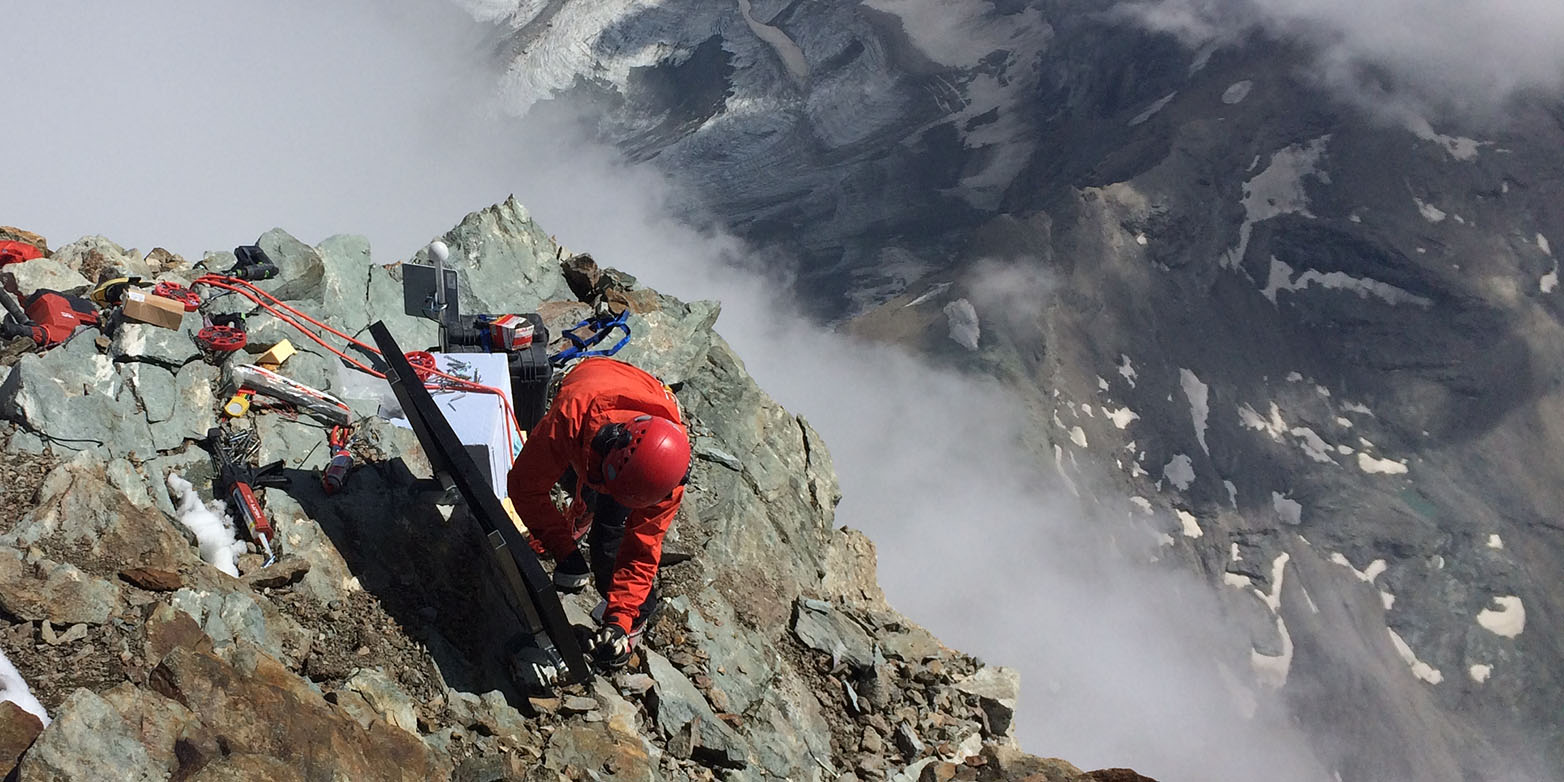 Science in lofty heights: Samuel Weber installs a seismometer and a solar panel on the summit of the Matterhorn. (Photograph: Jan Beutel / ETH Zurich)