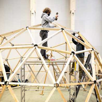 Two men assembling the domes framework