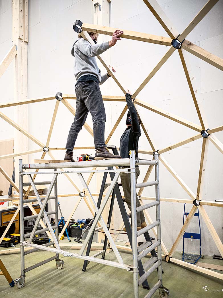 Two men assemble the dome framework