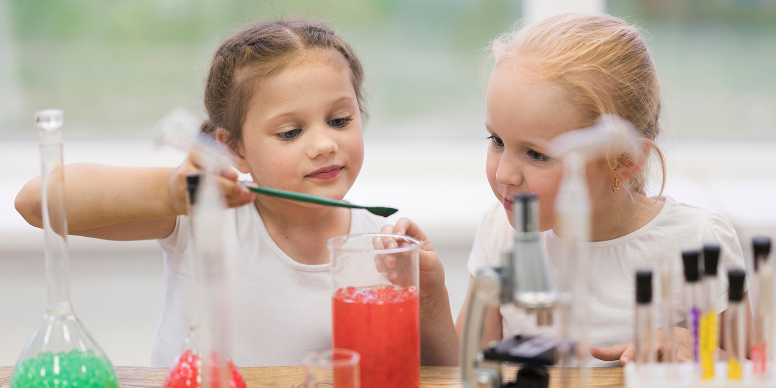 Two young girls experiment with a test tube