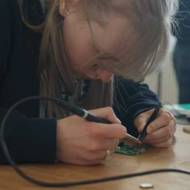 Student soldering on a circuit board