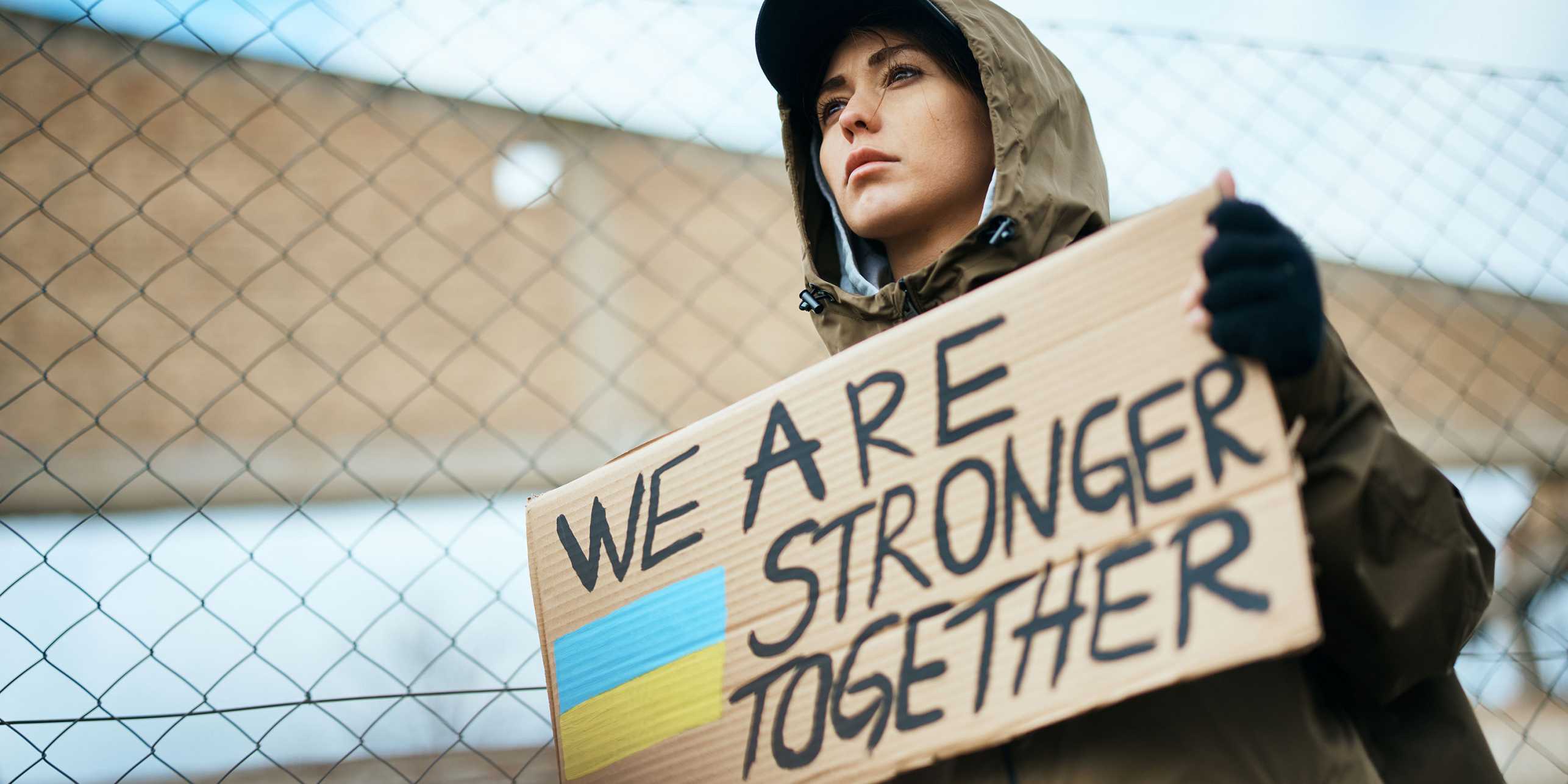A Ukranian protester holding a sign: "We are stronger together" 