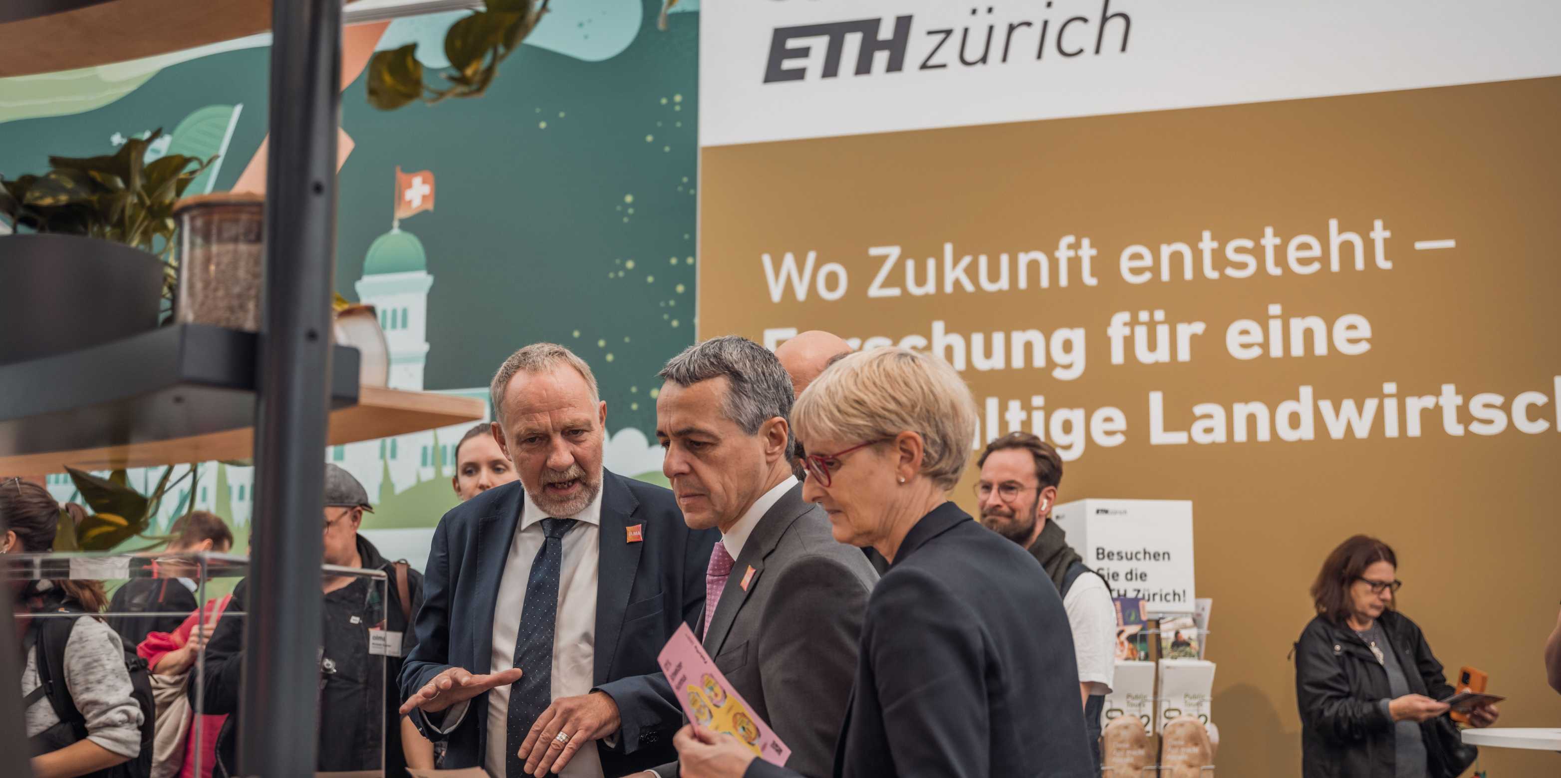 Detlef Günther (left) stands with Ignazio Cassis and another woman in front of the "start-up tower" of the ETH stand and talks. 