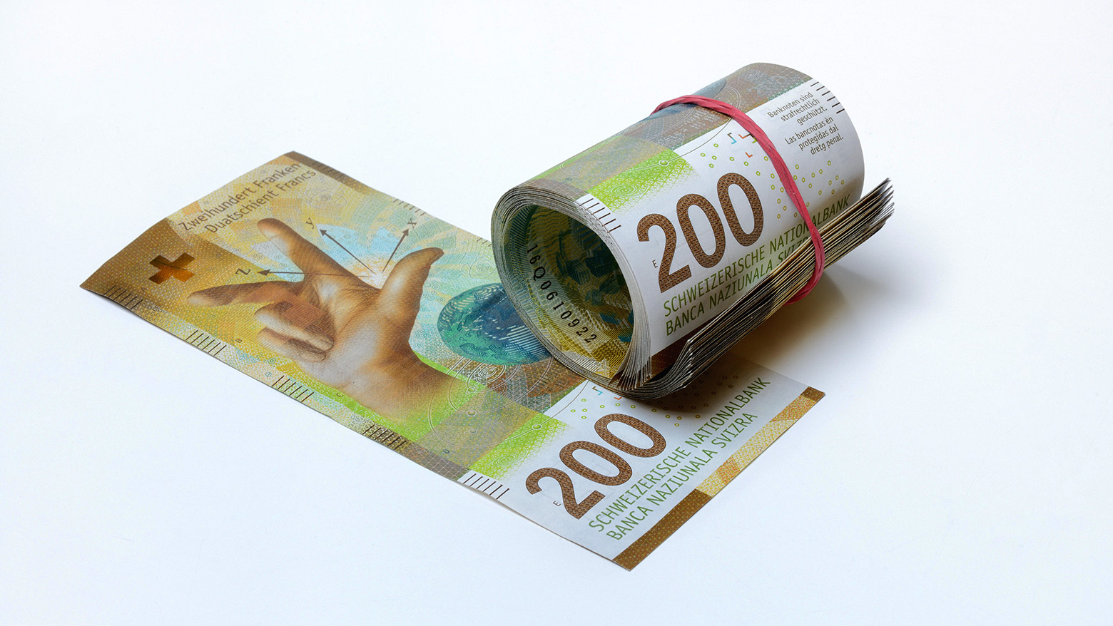 Rolled-in banknotes next to a 200 note.