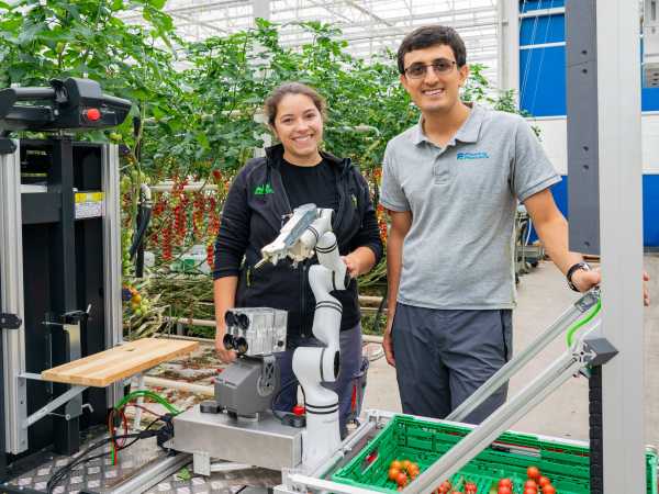 The founders with the picking robot in the greenhouse