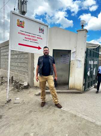 Onicio Batista Neto Leal standing at the entrance of a hospital in Kenya.
