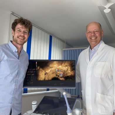 ETH researcher Fabian Laumer (left) and gynecologist Michael Bajka stand next to a screen showing an ultrasound image.