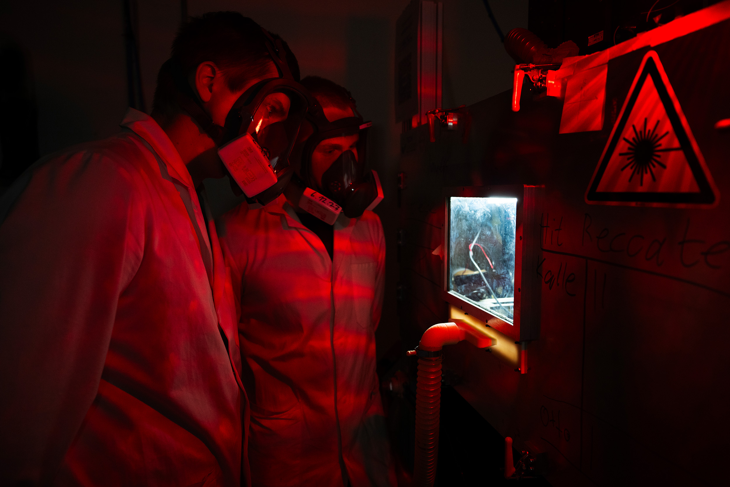 Students with gas masks in a dark room with infrared light.