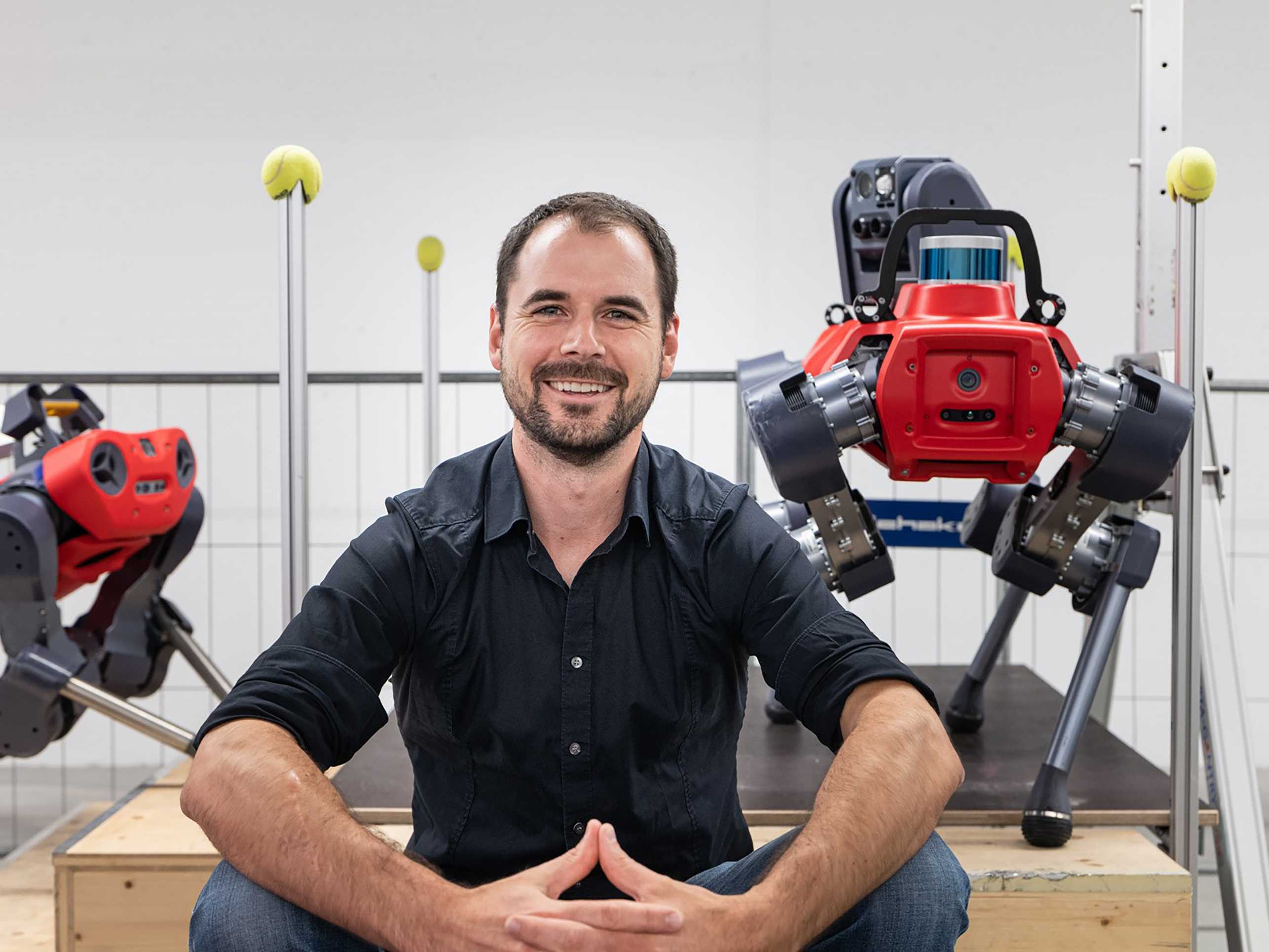 Marco Hutter sits in front of his two walking robots