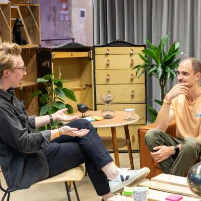 Four people sitting around a table talking in the Student Project House