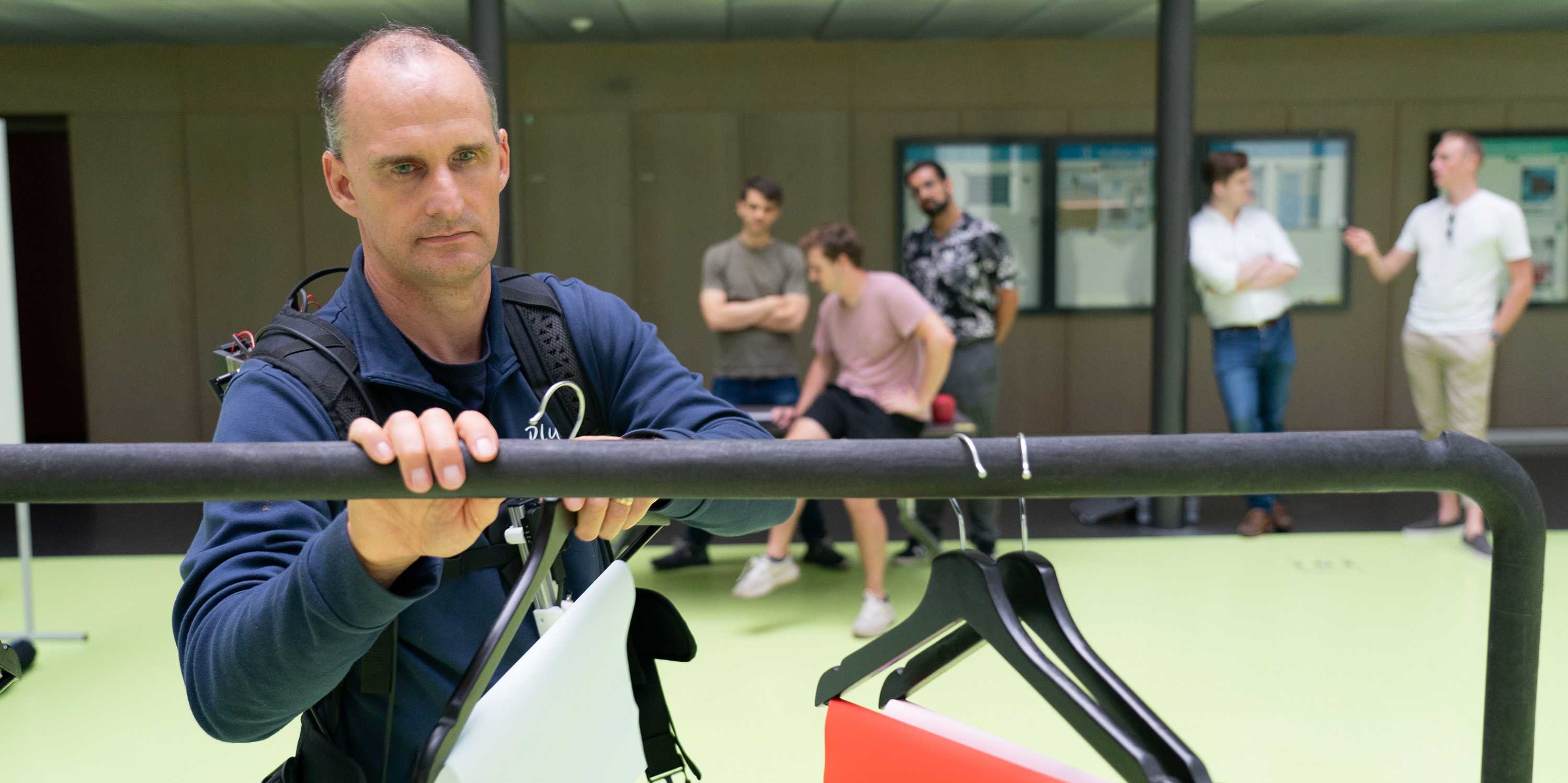 Cybathlon pilot Lukas Hendry sorts the different hangers by colour using the SightGuide team's technology