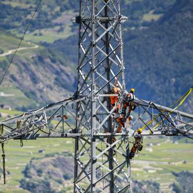 Fitters standing on an electricity pylon