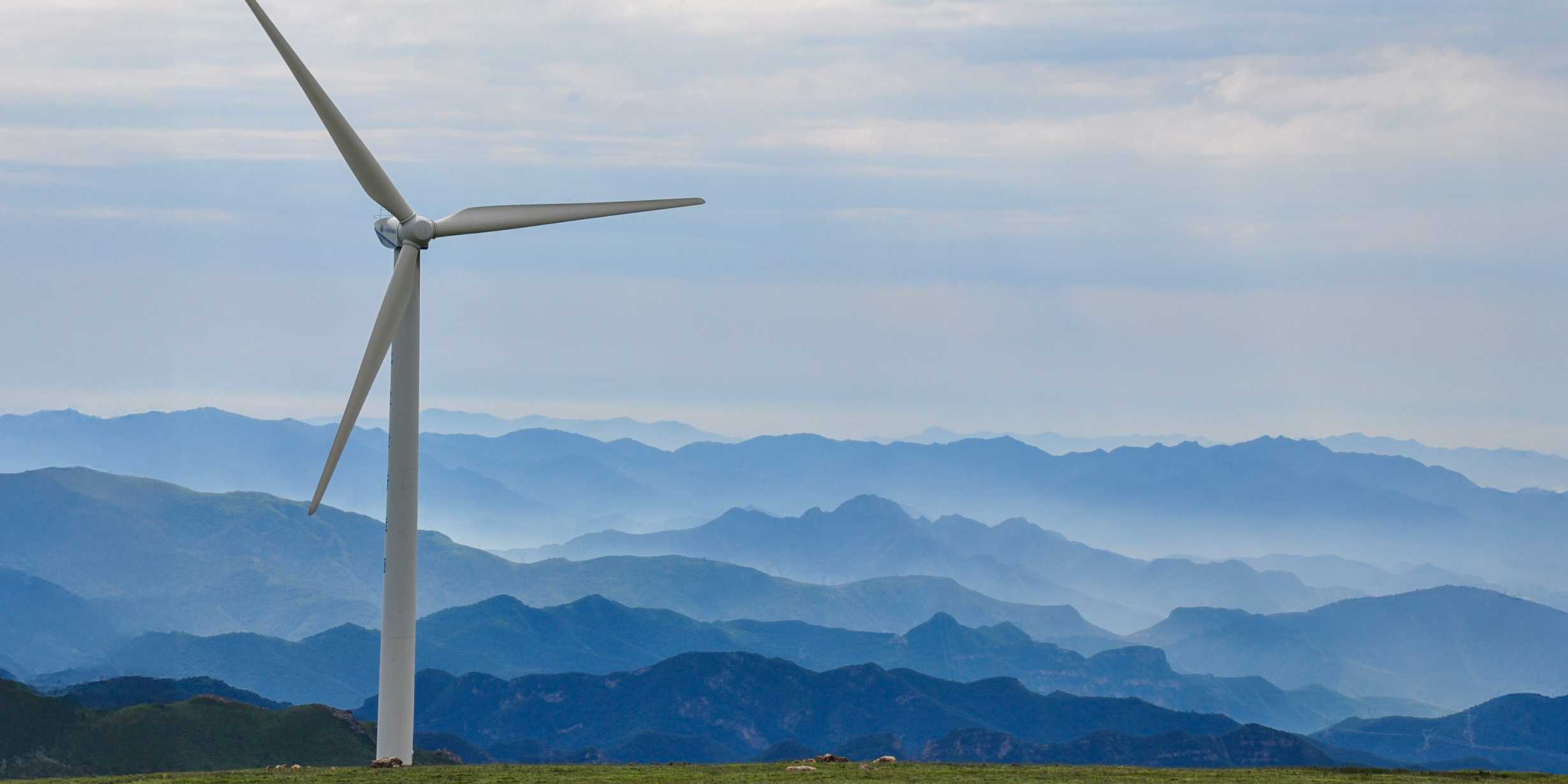 Wind turbine in front of a mountain landscape