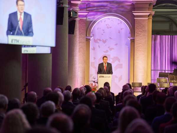 Albert Rösti stands on the stage in the main building of ETH Zurich and speaks to the audience.