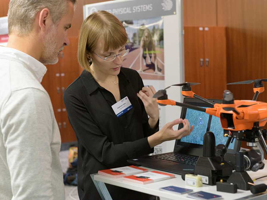 Woman showing a drone to an interested visitor