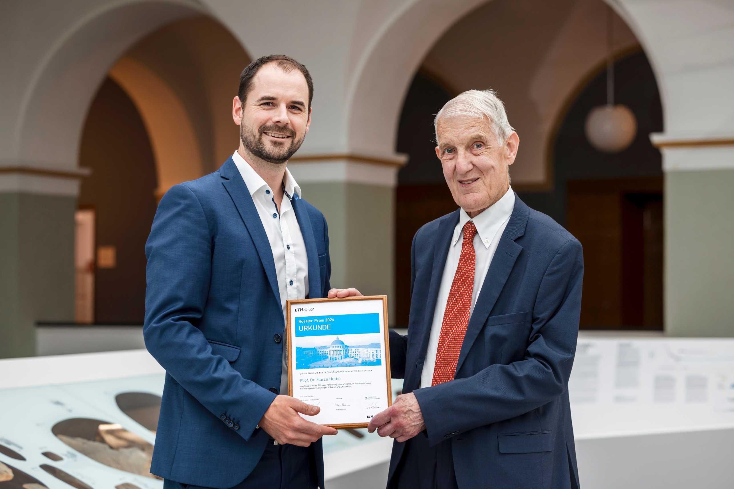 Marco Hutter receives the Rössler Prize certificate from Max Rössler