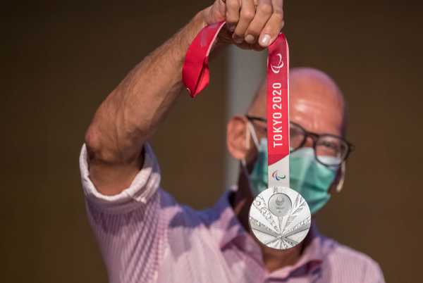 a person holding olympic medal