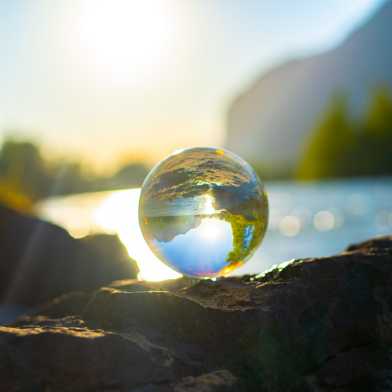 Crystal ball on rock in sunset