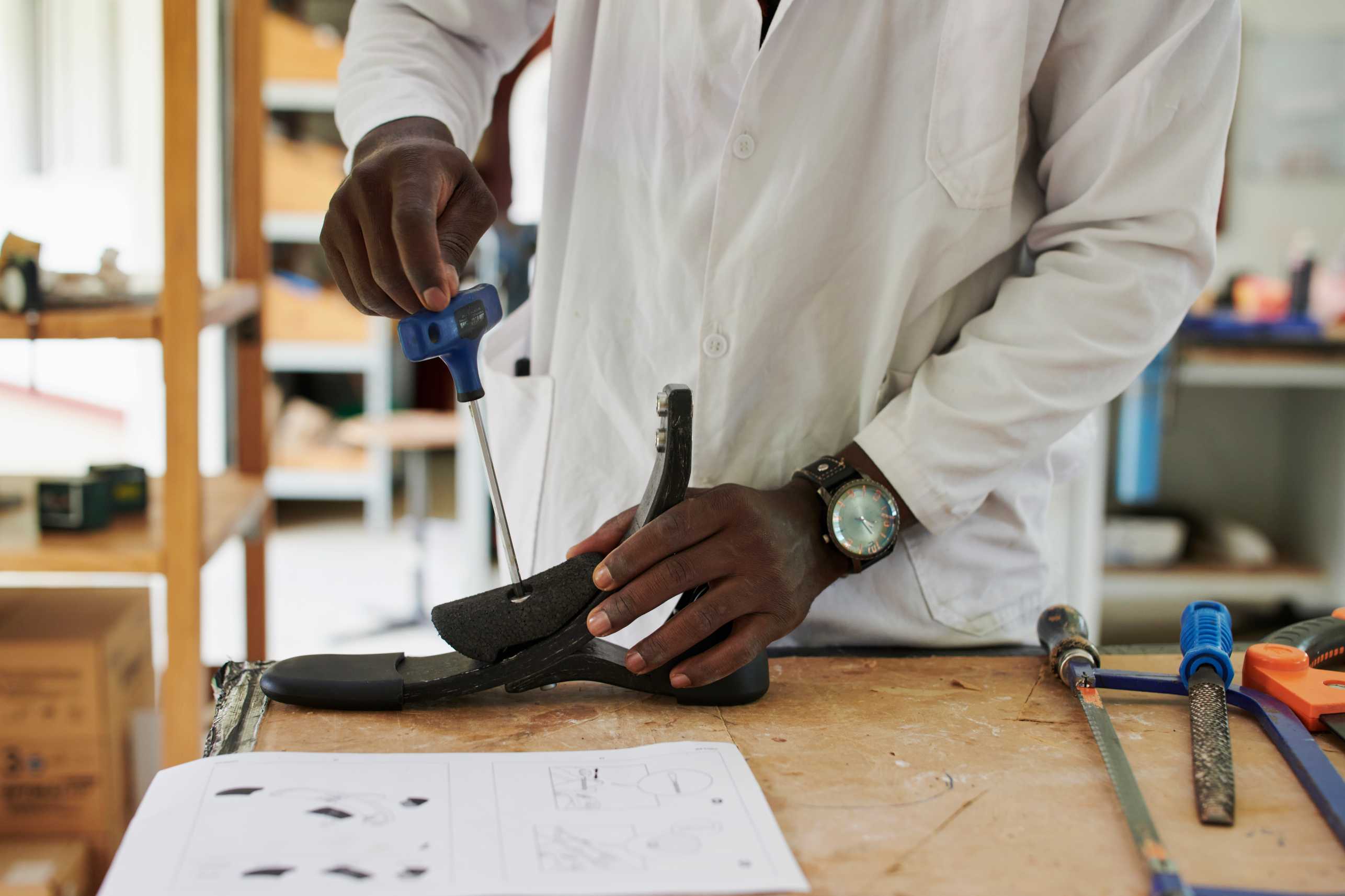 Hands of a man are seen working on the Circleg prosthetic legs in what appears to be a factory somewhere in Africa.