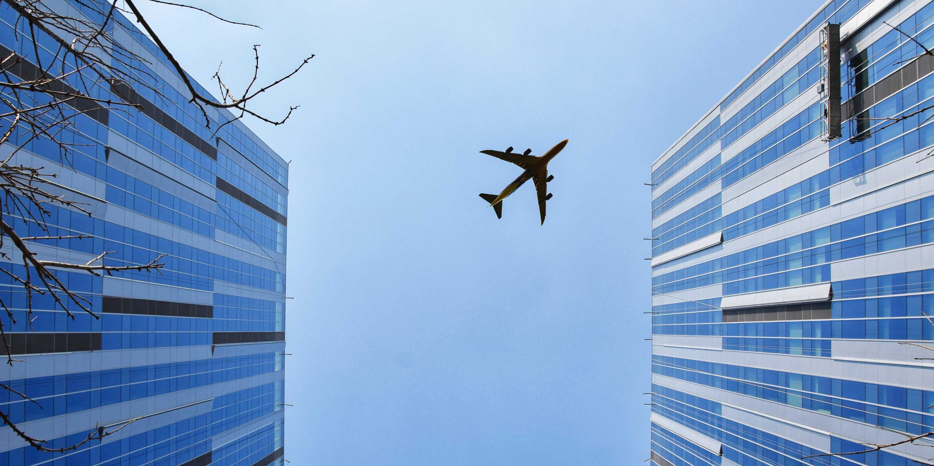 Ein Flugzeug fliegt über Gebäude
