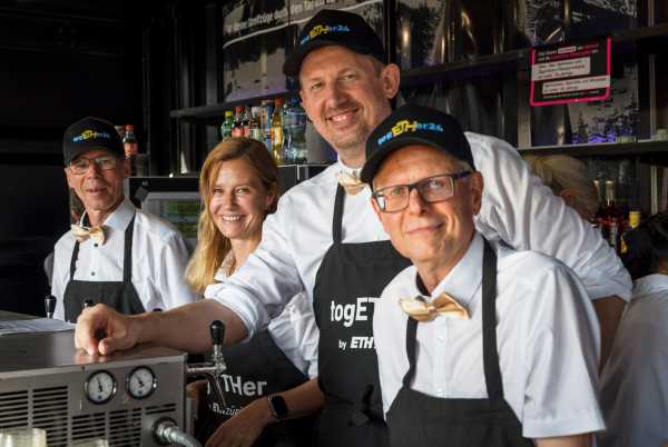 Die ETH Schulleitung zapft hinter der Bar beim Mitarbeitendefest.